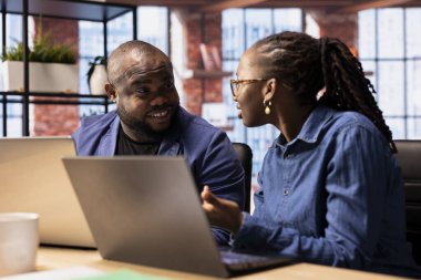 Dissatisfied woman expressing her concerns to her partner and getting angry, having an argument and being displeased with their work. African american boyfriend and girlfriend doing mistakes.
