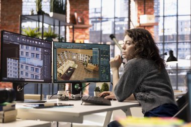 Kadın müteahhit, CAD yazılımını kullanarak bir iç tasarım projesi üzerinde çalışıyor. Detaylı bir kat planı, sanal varlıklar yaratmak için. Grafik tasarımcısı odayı ve düzenlemeleri ayarlamak için dijital araç kullanır.