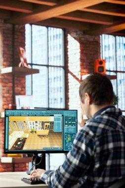 Interior designer uses architectural software on computer to help customers with remodeling job commission. Freelancer in home office preparing visual preview for clients on PC