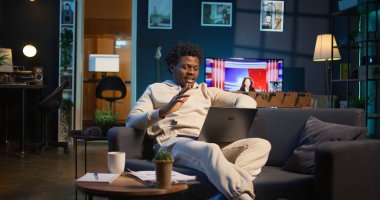 Antrenörüyle yaptığı sanal görüşmede gülümseyen uzaktan kumandalı bir erkek, online araçların ve internet bağlantılarının etkinliğini gösteriyor. Yeni iş için eğitime başlayan kişi. Kamera B.