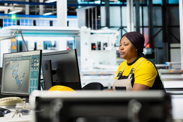Engineer using computer setup to monitor solar panel plant assembly lines, troubleshooting photovoltaic system to ensure seamless production line. Automation for renewable energy.