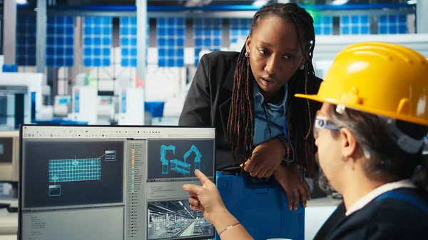 Fotovoltaik fabrikası yöneticisi yenilenebilir enerji jeneratörlerinin özel üretim modelleri tarafından yapılan çalışmaları denetliyor. Güneş panelleri, güneş pilleri inşa eden teknisyen ve kamera A 'yı denetleyen bitki denetleyicisi.