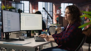 Uygulamalar oluşturmak için IT 'nin başlangıç ofisinde programlama dillerini kullanan gülümseyen kadın. A kamerasını kodlamak için yazılım geliştirme ajansındaki bilgisayarı kullanan iyimser programcı.