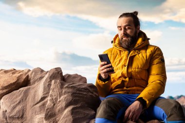 Trekker, yüksek rakımlı hava ve nefes kesen manzaranın farkındalığı teşvik ettiği dağlarda sakin bir anın tadını çıkarıyor. Rahatlama ve doğada kendini geliştirme.