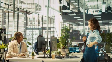 Çok ırklı iş arkadaşları başarıyı kutluyor, heyecanlarını dile getiriyor, beşlik çakıyor. Çok ırklı iş arkadaşları iş başarısından memnunlar, birbirlerini tebrik ediyorlar, kamera B