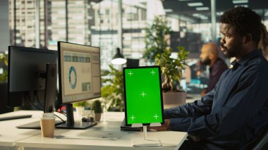 Ofiste çalışan işçilerin finansal grafikleri incelemek için kullandıkları izole ekran tabletini kapat. Çalışanlar veri eğilimlerini ve model tablet hakkındaki stratejik görüşleri inceliyor, KPI 'leri analiz ediyor, kamera B