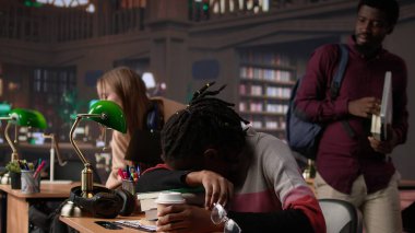 Afrika kökenli Amerikalı bir öğrenci kampüs kütüphanesinde kitap yığınının üzerinde uyuyakalıyor, tükenmişlikle uğraşıyor ve üniversiteden mezun olmak için mücadele ediyor. Yorgun genç bir öğrenci gece ders çalışmaya çalışır. Kamera B.