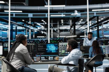 Developer with paraplegia and manager inspect neural network data center used for machine learning. Inclusive workplace worker and supervisor optimize server hub for artificial intelligence workloads