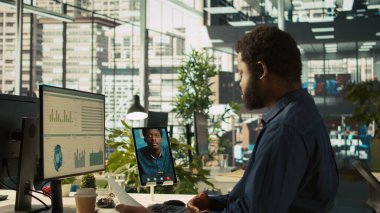 Video konferansında çalışanlarla sohbet etmek, performans ve şirket büyümesi için hedefler belirlemek. İşçilerle telekonferans toplantısının yöneticisi tablet, kamera B kullanıyor.