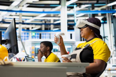 Fotovoltaik tesisi mühendisi güneş pilleri için yenilenebilir enerji üretmek için VR teknolojisi kullanıyor. Sanayi tesisi çalışanı sanal gerçeklik teçhizatı kullanarak güneş paneli yaratıyor.