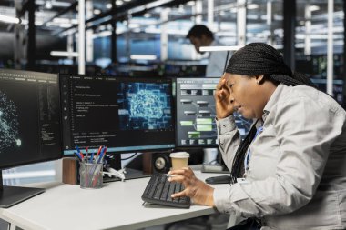 Yapay zekayı çalıştırmak için gerekli veri merkezi ekipmanlarını kurarken baş ağrısı çeken yorgun mühendis. Yapay zeka araçları kullanarak migrenden etkilenen yorgunluk sunucusu oda çalışanı