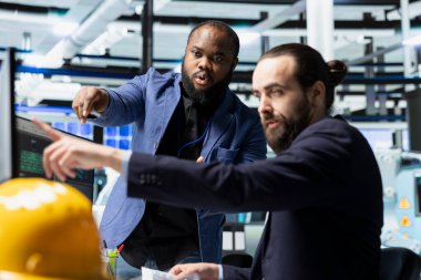 Takım elbise sanayi uzmanları güneş paneli fabrikasında beyin fırtınası yaparak yenilenebilir enerji ve altyapıyı geliştirmek için yeni fikirler üretiyor. Kurumsal kalkınma sağlanıyor.