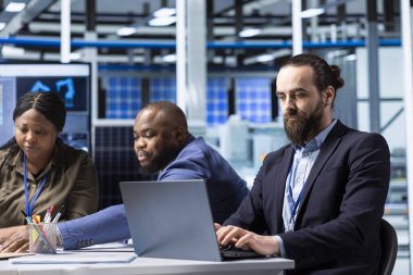 Fotovoltaik fabrikası mühendisleri güneş panelleri verimliliğini artırmak için dizüstü bilgisayar kullanıyorlar. Güneş panelleri, dizüstü bilgisayar kullanarak sürdürülebilir güneş çözümlerini araştıran fabrika çalışanları üretiyor.