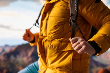 Zirvede duran kararlı dağcı huzurlu bir başarı anının tadını çıkarıyor. Uçsuz bucaksız gökyüzü, sıradağlar ve temiz hava özgürlüğün, refahın ve keşiflerin özünü vurguluyor..