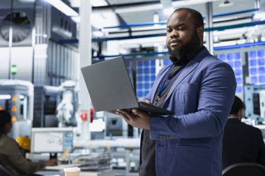 Endüstriyel danışman yüksek teknolojili güneş enerjisi üretim hattını inceleyerek, temiz enerji geliştirme, yenilenebilir sistem tasarımı ve akıllı altyapı planlama kavramlarını gözden geçirir..