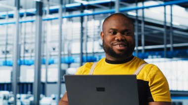 Mutluluk mühendisi, 4.0 endüstriyel sanayi santralindeki dizüstü bilgisayarını kullanarak makineler kuruyor ve eksiksiz testler yapıyor. Neşeli robot teknisyeni akıllı fabrikada IoT sensörlerini ayarlayan bir defter kullanıyor.