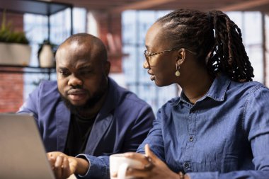 Afrika kökenli Amerikalı çift evlerinde uzaktan çalışıyor, iş stratejileri planlıyor ve proje geliştirmeyi tartışırken aynı zamanda bir dizüstü bilgisayarla ilerlemeyi takip ediyor ve başarıyı garantiliyor..