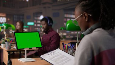 Genç kız öğrenci kütüphanede fotokopi alanı olan sınavlar için çalışıyor, üniversite gazetesi için akademik bilgiler topluyor. Lisans diploması araştırması. Kamera B.