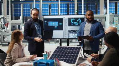 Fabrika yöneticileri yatırımcılara sürdürülebilir üretim çözümleri sunuyorlar. Endüstriyel fabrika yöneticileri, hissedarlara yenilikçi güneş paneli otomasyon teknolojileri sunuyorlar, kamera A