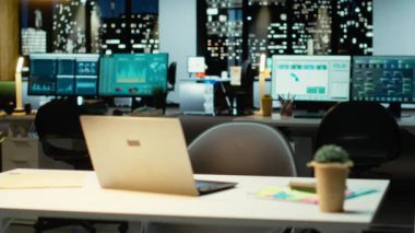 Geceleri boş bir iş bürosunda veri raporları ve analizler, gece yarısı parıltısı ve şirket yönetim kurulunda ışıklar sergileniyor. Yönetim için finansal tahminleri olan modern çalışma alanı.