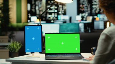 Masa başı müdürü laptopta yeşil ekranı, tablette mavi ekranı kullanıyor, yeni toplantılar düzenliyor ve haftalık gündemi planlıyor. Bir proje için işletme yönetimi görevleri. Kamera B.