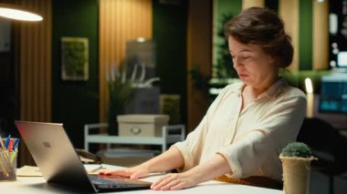 Mesai saatleri dışında karanlık bir ofiste rakamları ve finans rakamlarını araştıran yönetici, güncellemeleri belgeliyor ve iş sunumu gündemini düzenliyor. Hedefleri gece belirliyorum. Kamera B.