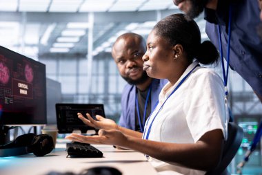 Sunucu merkezi elemanları donanımı korsan saldırısından koruyor ve hassas bilgileri çalıyorlar. Veri merkezi çalışanı, monitörde güvenlik ihlali uyarısı gördükten sonra virüsü silmek için beyin fırtınası yapıyor.