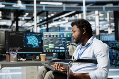 Paraplejisi olan kişi, yapay zeka sinirsel ağlarını kullanarak veri merkezinde çalışıyor. Bilgisayarda yapay zeka programlama dili kullanarak sunucu odasında engelli tekerlekli sandalye kullanıcısı, donanım yapılandırması