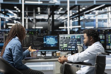 Belden aşağısı felçli biri, sunucu odasında ve iş arkadaşı, dinlenme zamanını azaltmak için yapay zeka kullanıyor. Tekerlekli sandalyede engelli mühendis ve iş arkadaşı veri merkezinde yapay zeka uyguladı