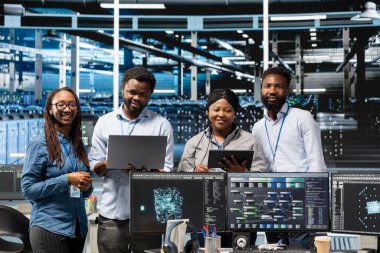 Yapılandırılmamış verileri sınıflandıran ve kümelendiren yapay zeka algoritmaları ve düğüm ağaçları kullanan gülümseyen sunucu merkezi mühendislerinin portresi. Doğal Dil İşleme Teknolojisini kullanan Mutlu Veri Merkezi çalışanları