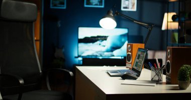 Geniş bir ev ofisi ve ahşap mobilyaları olan şık bir daire, rahat bir TV salonu, dekoratif ev bitkileri ve minimalist bir tasarım modern konforlu bir çalışma alanı ve yaşam alanı oluşturur..