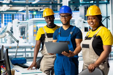 Siyahi mühendislerden oluşan bir ekip fabrikadaki güneş panelleri üretimini inceliyor ve üretim hattı için kalite kontrolü yapıyor. Alternatif enerji endüstrisi üzerinde çalışan denetçiler.