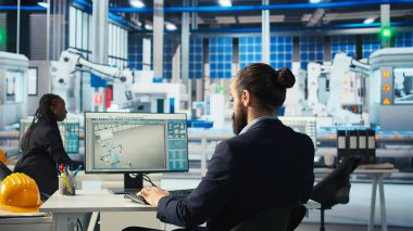 Fotovoltaik fabrikasındaki mühendis PC 'de kahve içiyor ve çalışan sistemleri teşhis ediyor. Güneş panellerinde içecekten hoşlanan bir adam fabrika üretiyor, dinlenme süresini azaltıyor, kamera A