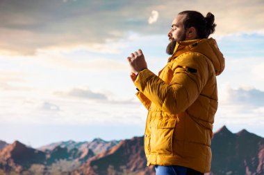 Genç kaşif dağın zirvesine ulaşıyor ve zirvede meditasyon yapıyor, sakin ve dikkatli bir şekilde zen meditasyonu yapıyor. Mutlu içerik arayıcısı kişisel bakım için doğayı seviyor.