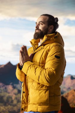 Huzurlu bir kâşif, stres atmak için meditasyon yapıyor. Dağın tepesinde rahatlık ve denge için dinleniyor. Genç gezgin, dikkat çekmek için meditasyon yapıyor..