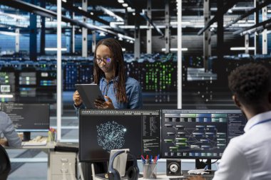 Veri Merkezi bilgisayar bilimcisi otomatik tekrarlanan görevleri denetlemek için yapay zeka görselleştirme programını kullanır. Sunucu merkezindeki kadın veri analizi grafiklerine dayalı altyapı donanımlarını modifiye ediyor