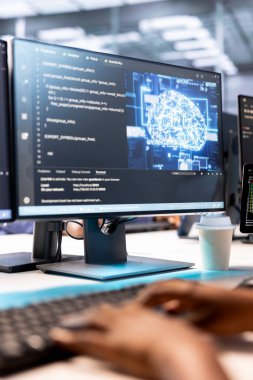 Verimliliği arttırmak için sunucu odasında yapay zeka teknolojisi kullanan bir teknisyen. Yapay zeka güdümlü çözümleri uygulamak için bilgisayar üzerinde çalışan veri merkezi çalışanının yakın çekim görüntüsü