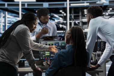 Veri merkezi çalışanları beyin fırtınası yapıyor, makine öğrenme eğitimi için kullanılan programlama ekipmanları. Yapay zeka sistemlerini güncellemek için bilgisayar üzerinde kod çalıştıran takım çalışması sunucu çiftliği arkadaşları