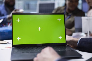 Fabrika müdürü, imalat stratejileri veri belgelerini yazmak için yeşil ekran dizüstü bilgisayar kullanarak yatırımcılar için hazırlanıyor. Krom anahtar dizüstü bilgisayara adam yazar, hissedarlar için rapor hazırlar