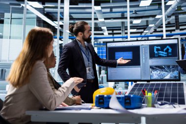 Fotovoltaik fabrikası yöneticileri potansiyel müşterilerle güneş enerjisi faydaları hakkında konuşuyor. Güneş paneli fabrikasındaki satış ekibi yatırımcılara ürün sunumu yapıyor, gelişmiş özellikleri vurguluyor