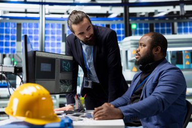 İki usta mühendis, yenilenebilir enerji sektöründe şirket liderliği ve takım çalışması sergilemek için bir güneş paneli tesisinde toplandılar. Sürdürülebilir geliştirme.