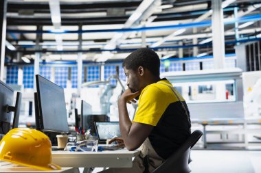 Güneş panelleri imalat tesisi denetleyicisi bir masaüstünde yeni fotovoltaik materyal ve teknolojiler geliştirir. Fabrika erkek işçi ince işçilik için teftiş yapıyor..