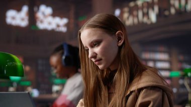 Üniversite kütüphanesinde akademik dersler için notlar toplayan, sınav hazırlıkları yapan ve diploma projesi üzerinde çalışan odaklanmış öğrenci kız. İhbar arayan genç bir yetişkin. Kamera A.