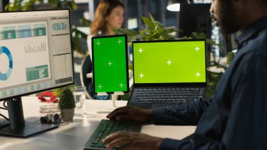 Krom anahtar tablet ve iş toplantısına hazırlanan çalışanların kullandığı dizüstü bilgisayar. Afrika kökenli Amerikalı bir adam tarafından kullanılan izole ekran cihazları başlangıç organizasyonu, kamera A için araştırma analizi yapıyor.