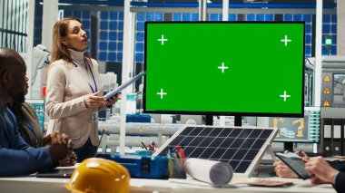 Fotovoltaik fabrikasındaki iş adamları görüntüdeki verilere bakarlar. Güneş panelleri fabrika yönetim ekibi ve yatırımcı anlaşma şartlarını yeşil ekran monitöründe gösteriyorlar, kamera B