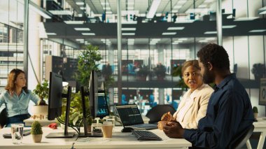 Neşeli yönetici, çalışanı iyi işi için tebrik ediyor. Ofisteki mutlu yönetici, iyi anahtar performans göstergelerini gördükten sonra memnun oldu. İşçi ve kamera B ile beşlik çaktı.