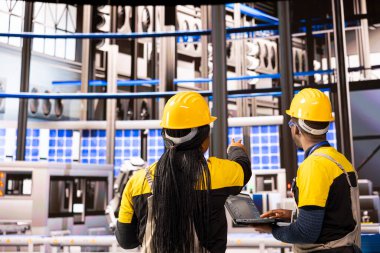 Gelişmiş üretim uzmanları yüksek teknoloji otomasyon hattı, robotik kollar ve taşıma bantları bakımını denetliyor. Akıllı fabrikada güneş panelleri üretiminde çalışan profesyonel mühendisler.