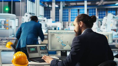 Fotovoltaik fabrikası teknisyeni sistem parametrelerini güneş pillerinin enerji üretimini maksimuma çıkarmak için dizüstü bilgisayara ayarlar. Güneş paneli imalat tesisinde enerji kaynağını optimize eden defter kullanan adam, kamera A