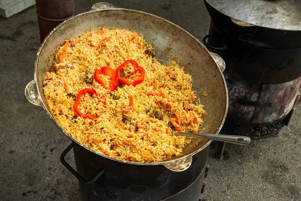 Pilaff med kött i en stor stekpanna i fria — Stockfoto