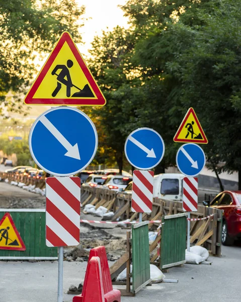 Cartello di riparazione stradale su una recinzione verde in una città — Foto Stock